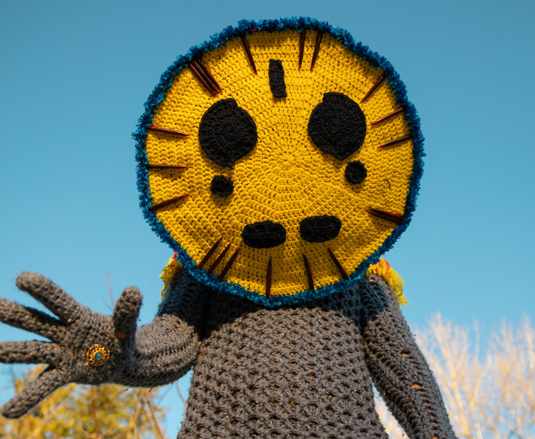 A figure wears a crocheted costume covering their entire body, habds and legs